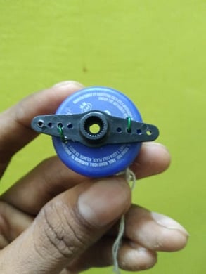 servo motor shaft connected to a bottle cap using the copper wires
